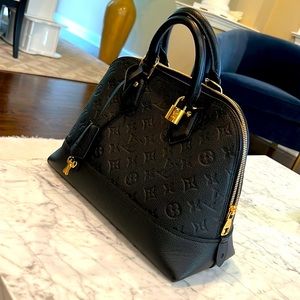 The Neo Alma PM handbag in embossed Monogram Empreinte leather has a soft.